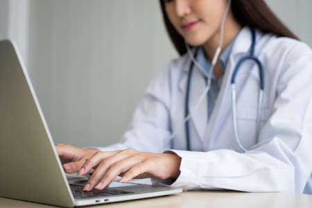 Asian woman doctor is online visiting with a patient on the internet application and Listening of the symptoms and explains how to treat the initial disease, Concept of Medical technology.の写真素材
