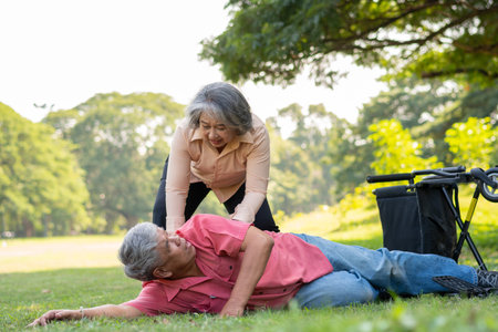 Asian senior man falling down from wheelchair on lying floor after trying push the wheelchair...