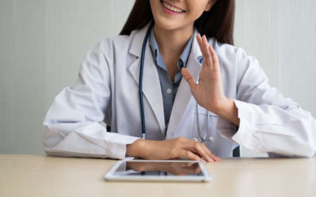 Asian therapist woman doctor is online visiting with a patient on the internet application. Her Listening and Give advice and explains how to treat the initial disease, Concept of Medical technology.の写真素材