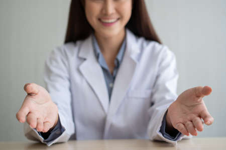 Asian doctor is online visiting with a patient on the internet application and make a note of the symptoms and explain how to treat the initial diseaseの写真素材