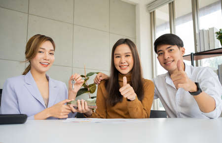 The real estate agent gives the key to client after signs the home loan document with the real estate property agent or lawyer.  Concept of insurance or loan real estate, buy a house.の写真素材