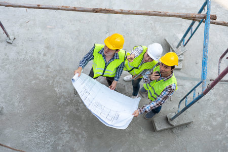 Top view of Asian engineer or Young Female Architect put on a helmet for safety and talk with a...
