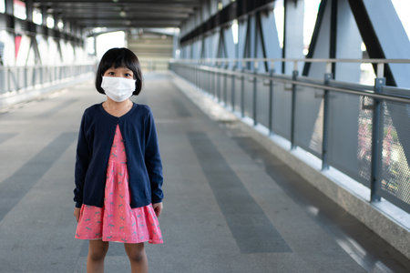 Little girl with surgical mask face protection flu and Virus outbreak in public transportation (skytrain or subway). Concept of New normal lifestyle, Using public transport to travel to school.の写真素材