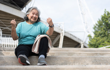 Happy and smile elderly asian woman sitting on stairs for rest after workout, jogging on morning,...