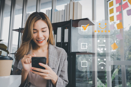 Businesswoman gives ratings to service experience on a smartphone, Service Provider Satisfaction Ratings and Evaluations,  Satisfaction concept and Customer servicesの写真素材
