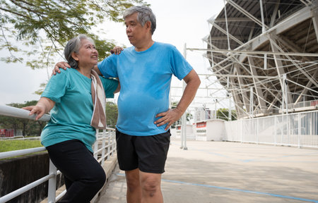 Happy and smile couples elderly asian standing on stairs for rest after workout, jogging on morning, senior exercise outdoor for good healthy. Concept of healthcare and active lifestyle for healthyの写真素材
