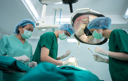 Asian Professional surgeons team performing surgery in the operating room, surgeon, Assistants, and Nurses Performing Surgery on a Patient, health care cancer and disease treatment conceptの写真素材