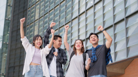 Group of happy young entrepreneurs with hands up and laughing to celebrate and excited success for achievements obtained. Undergraduate students celebrate success after end project, teamwork conceptの写真素材
