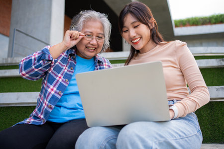 Focused young students listening old senior aged teachers for advise capstone project in university. Happy middle aged teacher working together with students for graduation project.の写真素材