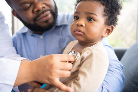 Pediatrics doctor with stethoscope for lungs or chest checkup for examining cute little girl in medical healthcare hospital or clinic. Doctor check Heart And Lungs for Smiling African American Baby.の写真素材
