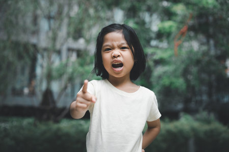 Portrait of angry emotional Asian girl screaming and frustrated shouting with anger, crazy and yelling on white background, Concept of attention deficit hyperactivity disorder ADHDの写真素材