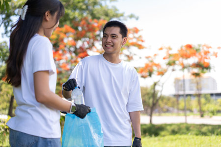 Happy young Asian students diverse volunteers with garbage bags cleaning area in the park, The concept of environmental conservation on world environment day, recycling, charity for sustainability.の写真素材