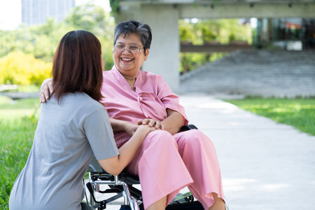 Asian careful caregiver or nurse taking care of the patient in a wheelchair.  Concept of a happy retirement with care from a caregiver and Savings and senior health insurance, encourage the patientの写真素材