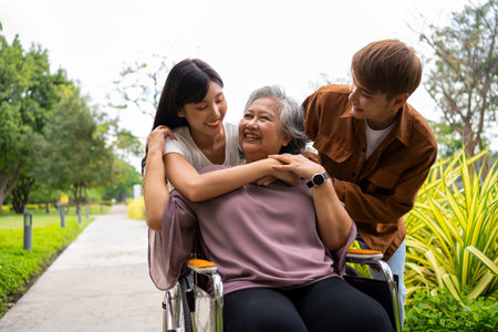 Asian careful caregiver or nurse taking care of the patient in a wheelchair.  Concept of a happy retirement with care from a caregiver and Savings and senior health insurance, a Happy Familyの写真素材