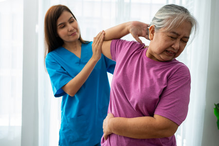 A young Asian women Physiotherapist Nursing is assisting an elderly woman exercise stretching muscles at home or a premium clinic for recovery, concept of Physical Therapy.の写真素材