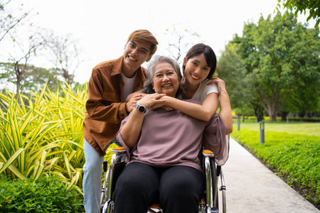 Asian careful caregiver or nurse taking care of the patient in a wheelchair.  Concept of a happy...