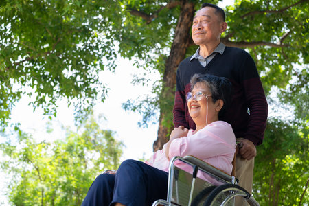Elderly couples or caregivers take care of the patient in a wheelchair. Concept of a happy retirement with care from a caregiver and Savings and senior health insurance, a Happy Familyの写真素材
