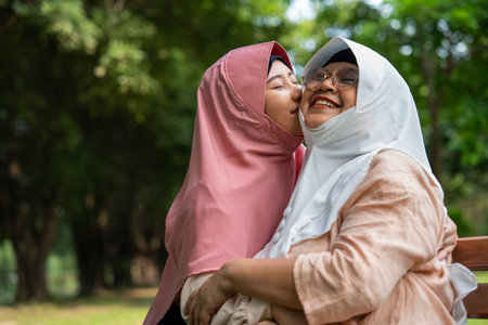 Happy Muslim mother in hijab hugging daughter.の写真素材