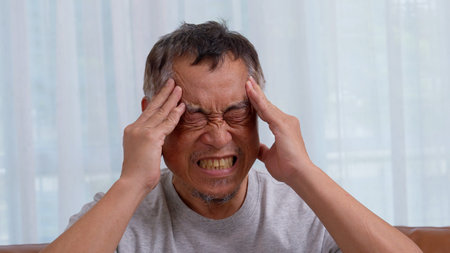 Depressed Asian senior man lonely disappointed and lose memory in the living room at home. Portrait...