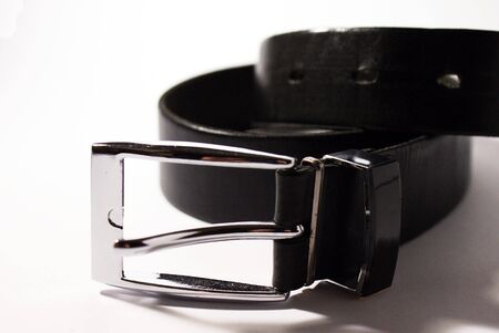 Black leather belt with a metal buckle isolated on a white backgroundの写真素材