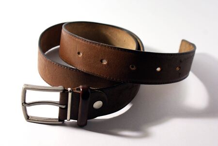 Brown leather belt with a metal buckle isolated on a white backgroundの写真素材