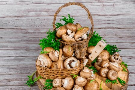 Raw brown mushrooms champignon in a wicker baskets with knife.の写真素材