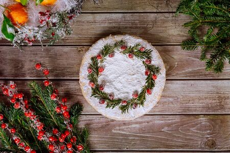 Christmas pie with pine branch and cranbarries on the top on wooden table.の写真素材