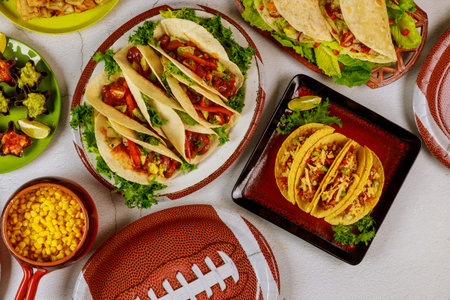 Table full of delicious snack for football game watching party for fans. Mexican food.