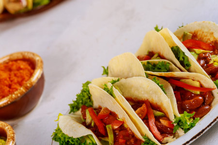 Colorful tortillas with beans, beef and vegetable with salsa. Mexican food.の写真素材