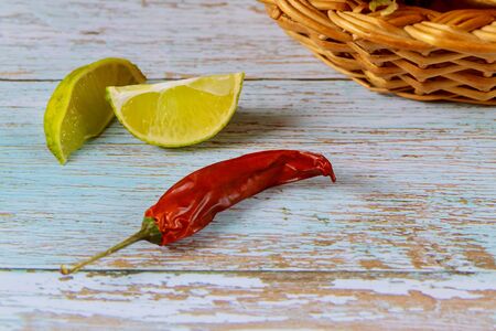 Red chili pepper with slices of lime on blue wooden table.の写真素材