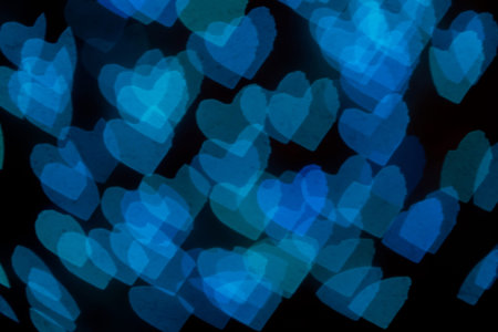 Blurred blue hearts bokeh on black backgrount. Valentines day concept.