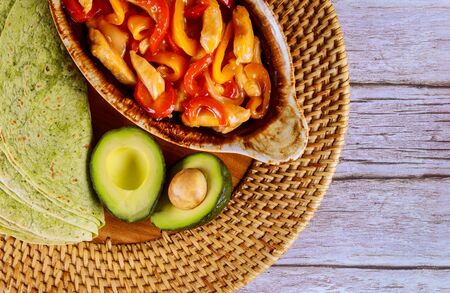 Fajita in baking tray with spinach tortillas on wooden background. Mexican cuisine.の写真素材