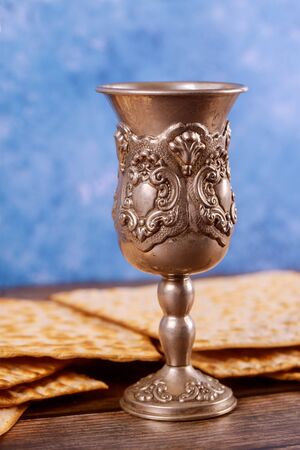 Jewish silver cup with wine with matzos. Passover holiday concept.の写真素材