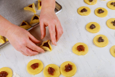 Making hamentaschen cookies with jam for Purim. Jewish holiday concept,