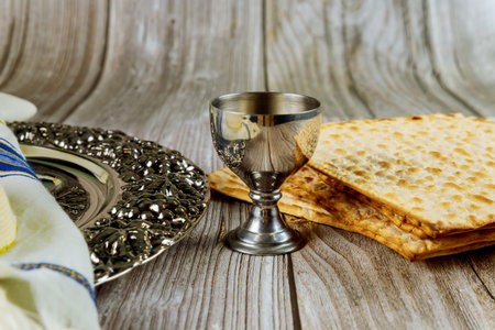 Matza, tallit and kosher kiddush on wooden background. Jewish holiday concept.