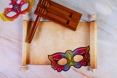 Papyrus roll with Purim masks and noisemaker for festival. Jewish holiday concept.の写真素材