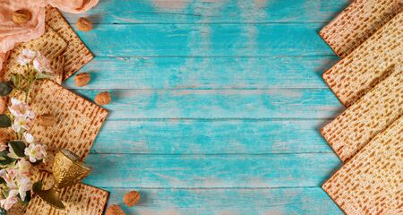 Jewish matzah bread with silver cup and flowers on wooden rustic background. Passover holiday conceptの写真素材