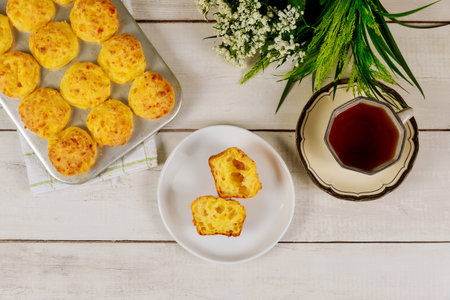 Brazilian cheese bread with tea on white wooden background. Top view.