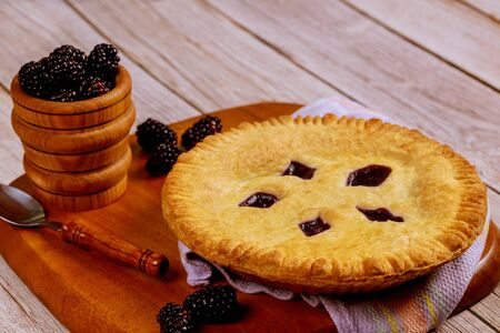 Blackberry pie and fresh berries on rustic wooden table.の写真素材