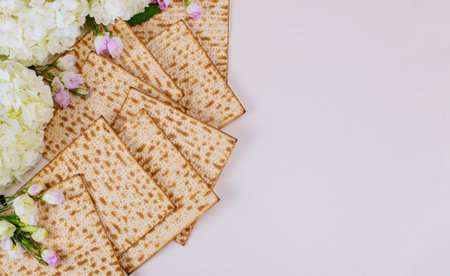 Jewish matzah bread with white flowers on white background. Passover holiday concept
