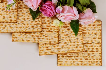Matzah bread with pink roses. Jewish Passover holiday concept. Close up.の写真素材