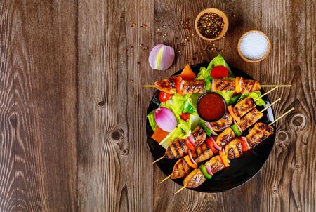 Grilled chicken on wooden skewer with hot sauce.の写真素材