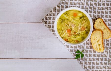 Chicken noodle soup in white plate with parsley and bread. Top view.の写真素材