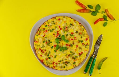 Cauliflower omelette with fork and knife on yellow background. Top view.の写真素材