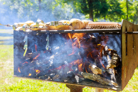 Outdoor charcoal grill with flame, smoke and meal.