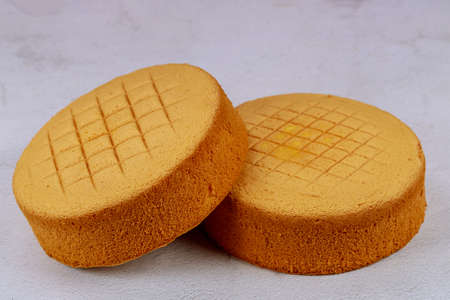 Sponge cake befor cutting and decorating on white background.の写真素材