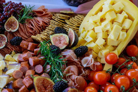 Charcuterie board with assortment of cheese, fruits and deli. Close up.