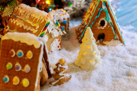 Homemade Christmas gingerbread houses with christmas tree on the snow.