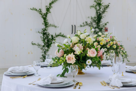 Flowers, white plates and glasses served for dinner in restaurant.