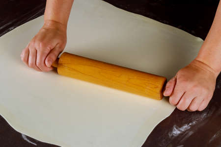 Woman rolling white fondant for cake decorating.の写真素材